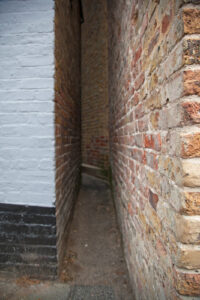 Squeeze Gut Alley in Whitstable seen from the Island Wall end, narrowing between high brick walls