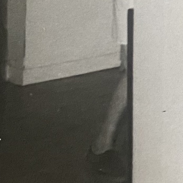 A fifth person in the doorway at V C Jones, Harbour Street, Whitstable, seen only as a white overall, a leg and a foot on the floor