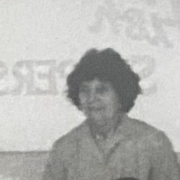 Unidentified woman in a light overall standing among the tables inside V C Jones, Harbour Street, Whitstable